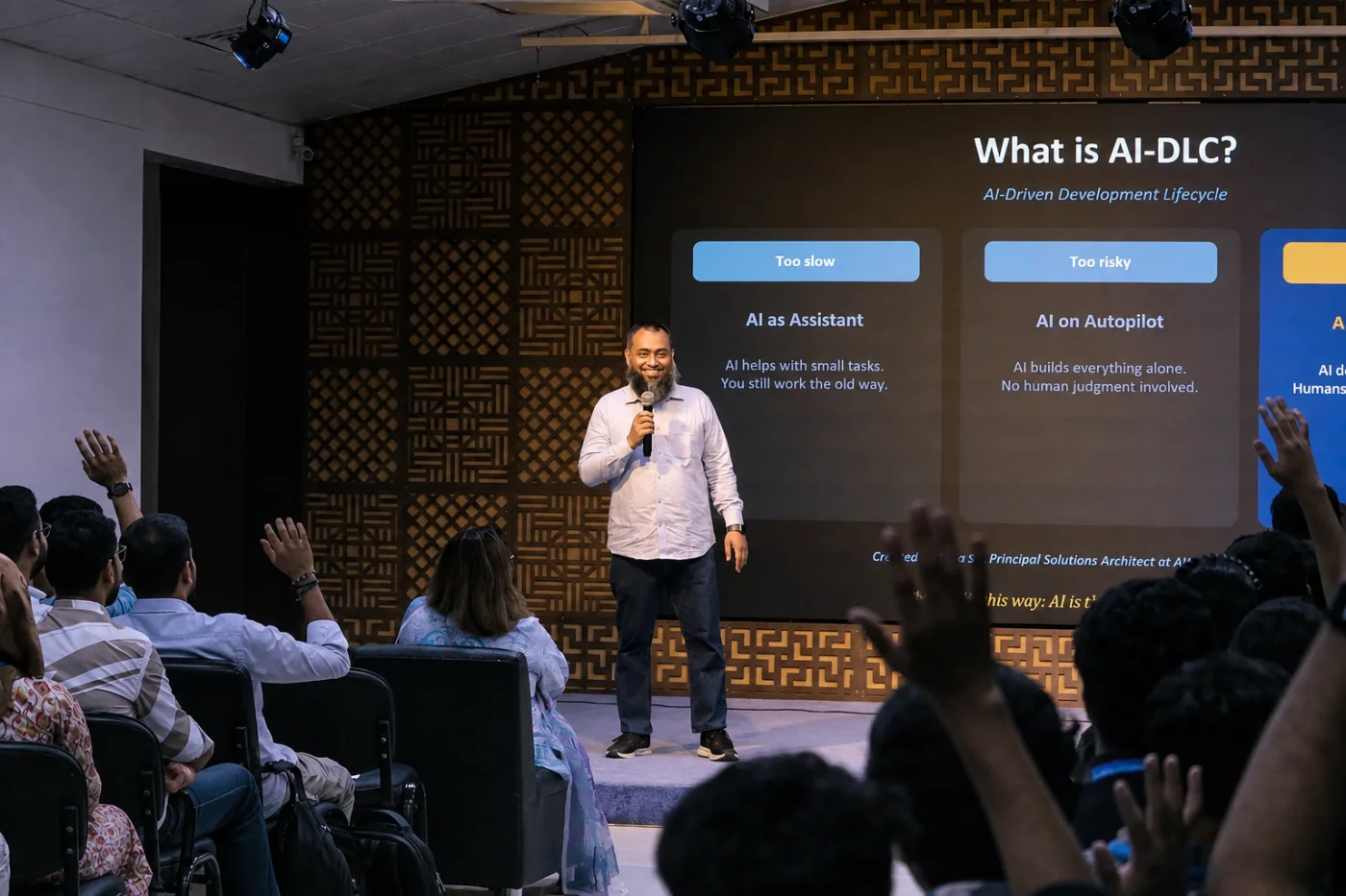 A MentoGrid trainer presenting an AI-DLC session to a full room, with attendees' hands raised to ask questions